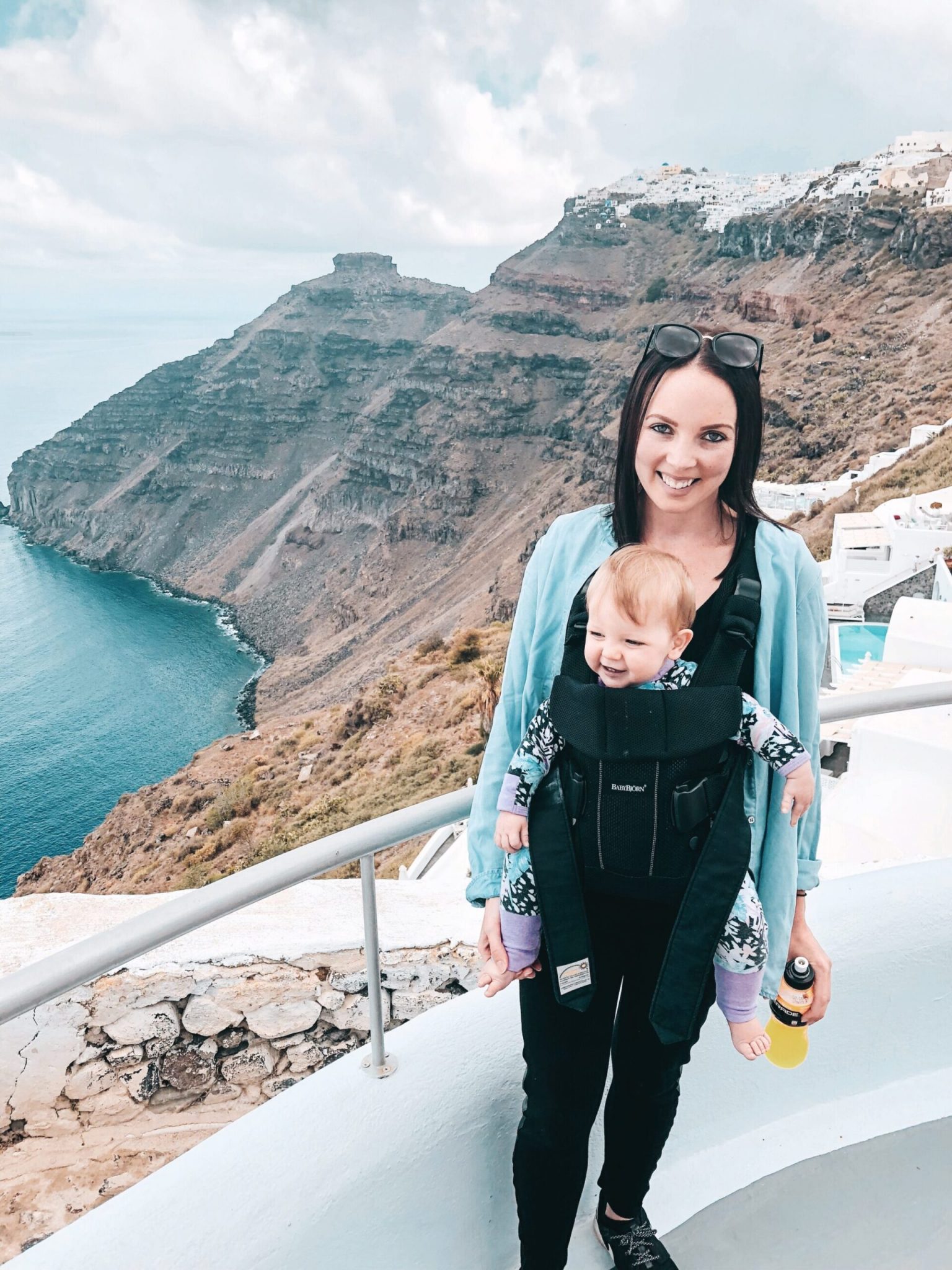 Mum & baby in Baby Bjorn carrier in Santorini, Greek Islands. Travel with a baby to Santorini for the most memorable family holiday.